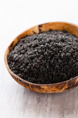 Sea salt in bowl, aroma oil in bottles, Wellness and flowers on grey textured background and flowers on vintage wooden background. Selective focus.