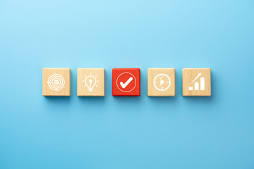 Business plan concept with wooden blocks with icon business strategy on blue background