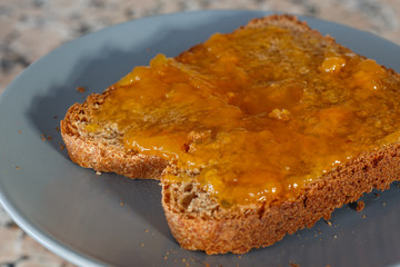 Thick toast with peach jam on blue plate