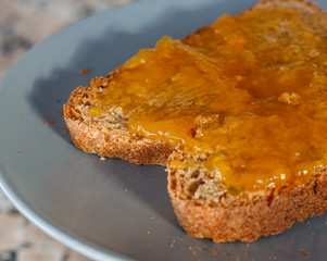 Thick toast with peach jam on blue plate