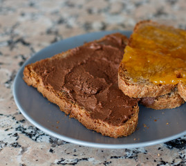 Slice toast with cocoa cream and peach jam on blue plate