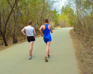 Sports training. Young boys jogging in the park Back view. Healthy lifestyle. Health and fitness.