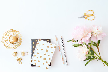 Blogger or freelancer workspace with notebook and light pink peonies on a white background