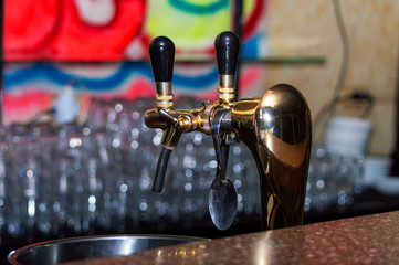 Copper beer taps in a dark bar