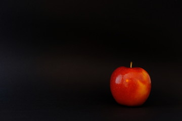 roter Apfel vor schwarzem Hintergrund