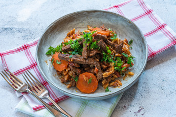 Giouvetsi - traditional Greek baked dish with beef and orzo pasta in tomato sauce.
