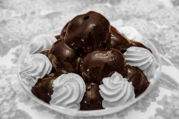 Tray of chocolate profiteroles with cream