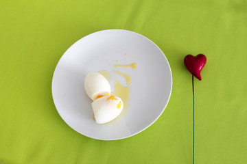 Plate of boiled eggs on green background, top view