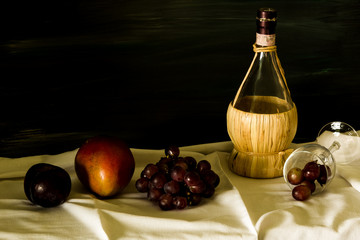 Artistic Lighting on Wine Bottle with Mango and Grapes and Plum on Dark BG with Copy Space