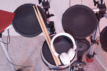 Music, hobby, musical instruments concept - drum with drumsticks and headphones, top view