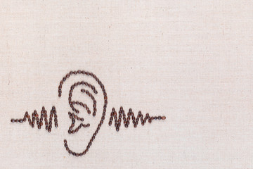 Ear and a sound wave made from coffee beans,aligned at the bottom left.