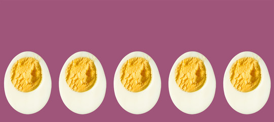 Row of boiled egg halves on a purple background - Powered by Adobe