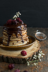 Vegan pancakes with chocolate sauce and  raspberries