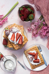 Homemade Waffle with strawberries and whiped cream.