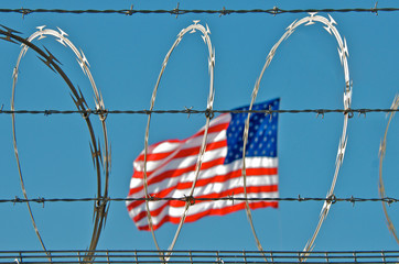 Border Fence.  Razor Wire, Electrified Barbed Wire and the American Flag. “So close yet so far”