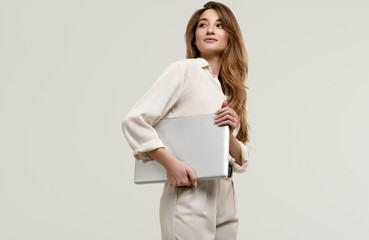 Gorgeous brunette model posing in white clothes with laptop