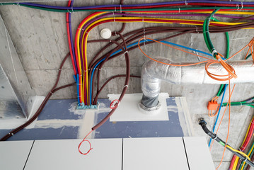 colorful plastic tubes for electrical wires in the sub ceiling in a massive wiring system