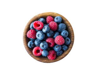 Top view. Berries in bowl on white background. Ripe raspberries and blueberries. Background of mix berries with copy space for text. Mix berries isolated on a white background. Various fresh summer.