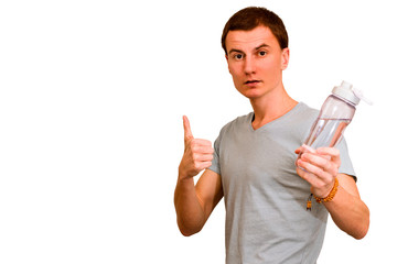 A young guy holds a bottle of water in his hand. The concept of proper nutrition and diet