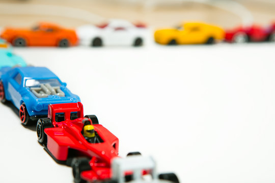 Multi-colored Toy Cars Are Lined Up On A White Background.  Copy Space For Text