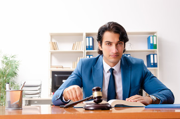 Young handsome judge sitting in courtroom  