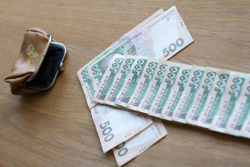 The arrow from the bills of the Ukrainian currency shows the direction in a small wallet