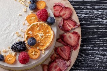 Dietary delicate fruity berry nut cake without baking. Wooden stand on a black table.