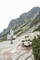 Naklejka na ściany i meble tourist with backpack hiking in moutains