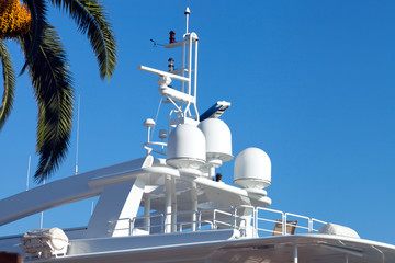 Top deck of luxury modern yacht with navigational equipment, under palm tree .