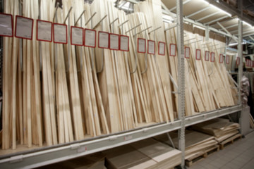 Sale in DIY shopping center. Lumber warehouse with wooden planks. Professional retail market for carpenter and builder. Blurred. Concept.