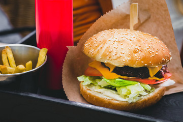 Fresh delicious burger with french fries on the black wooden table