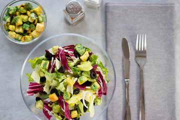Salad of mix leaves with croutons and olive oil in glass bowl. Concept vngetarianism.