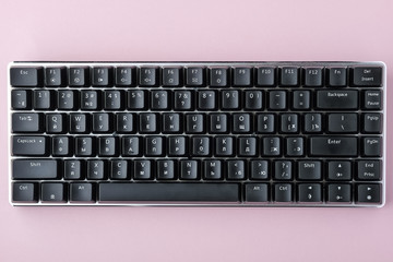 Black mechanical keyboard on pink background