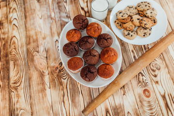 Photo of cookie and chocolate muffins on wooden desk!