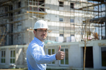 Architect at the construction site shows thumbs up..