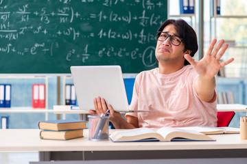 Young male student in the classroom 