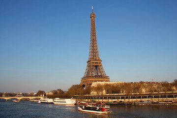 Fototapeta na wymiar The Eiffel tower in evening and river boat on the seine river in Paris, Paris capital and the most populous city of France