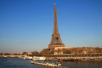 Fototapeta na wymiar The Eiffel tower in evening and river boat on the seine river in Paris, Paris capital and the most populous city of France