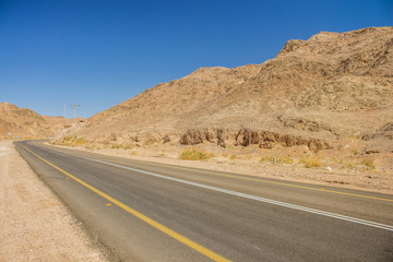 Fototapeta na wymiar country side empty car road in desert dry rocks sand stone outdoor environment, driving and transportation object 