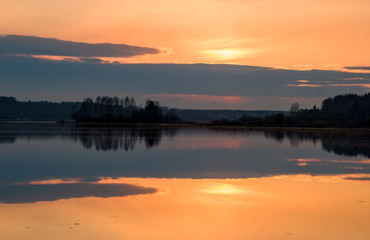 Early spring. Beautiful sunset on the wild nature. Forest river