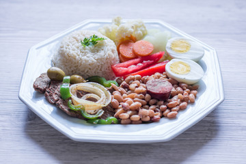 Brazilian food dish - Beans, rice, meat, eggs, salad