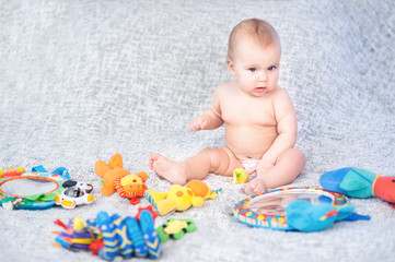 baby lying on Developing rug. playing in Mobile. educational toys. Sweet child Crawling And Playing With Toys On Carpet