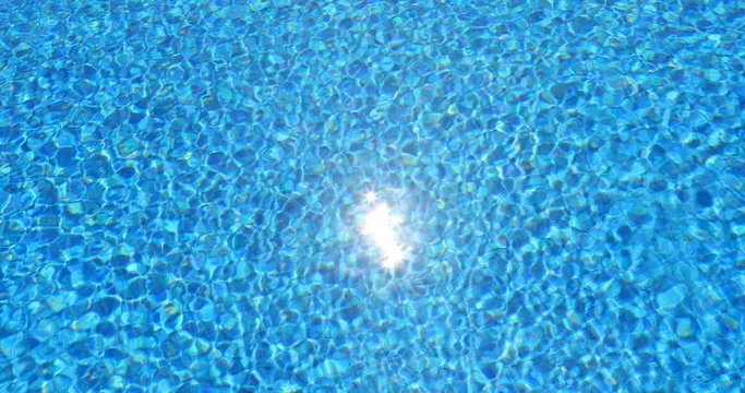 water ripples and sun hightlight in swimming pool, blue background, 4k loop-ready