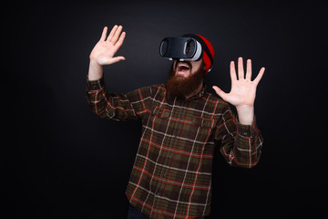 Photo of bearded man with Vr glasses,  happy and scared by virtual reality