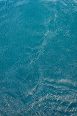 Turquoise ocean water with pattern and texture is small waves as a nature background