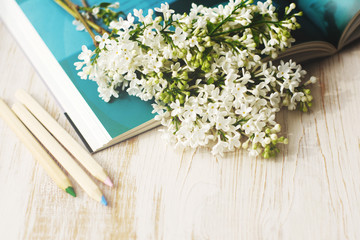Spring romantic bouquet of a white lilac on the open book. Greeting card
