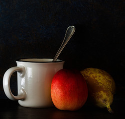 WHITE COFFEE CUP WITH NECTARINE AND PEAR FOR BREAKFAST.