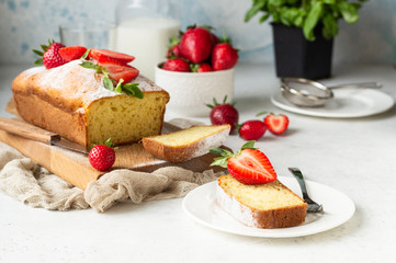 Pound or loaf cake with strawberry and mint on wooden board. Delicious summer dessert.