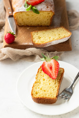 Pound or loaf cake with strawberry and mint on wooden board. Delicious summer dessert.