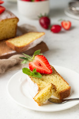 Pound or loaf cake with strawberry and mint on wooden board. Delicious summer dessert.